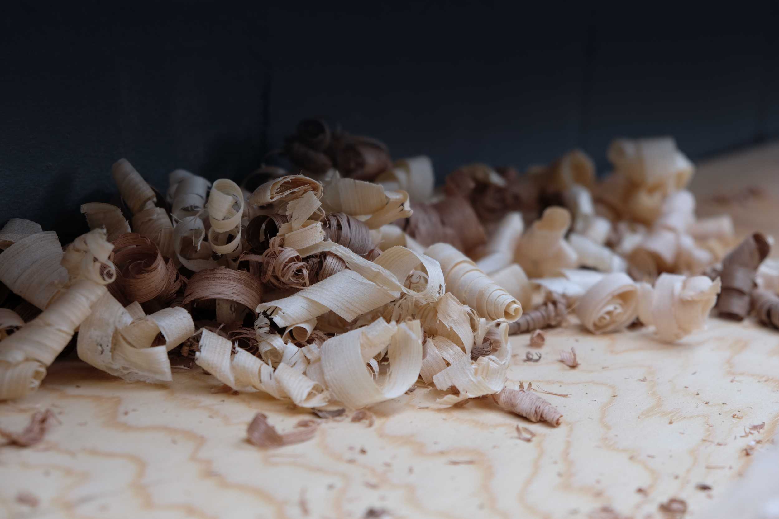 Colourful wood shavings on a workbench.